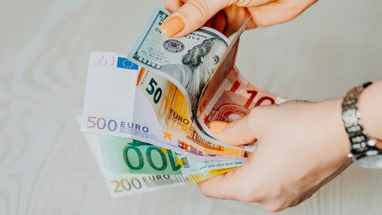 Manos sosteniendo billetes (dinero)