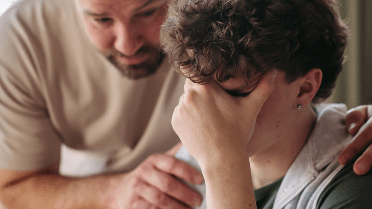 Padre acercándose a su hijo angustiado