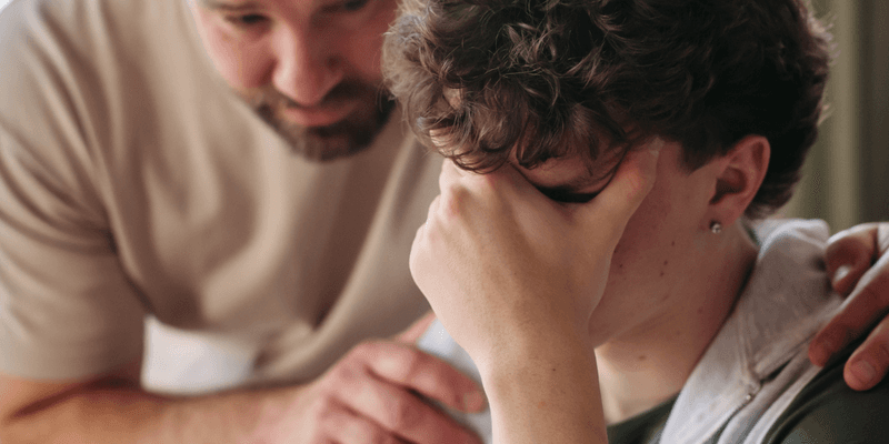 Padre acercándose a su hijo angustiado