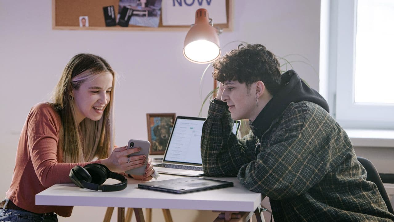 Dos jóvenes adultos participan en una conversación