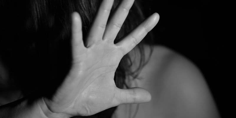 Mujer asustada protegiéndose con la mano