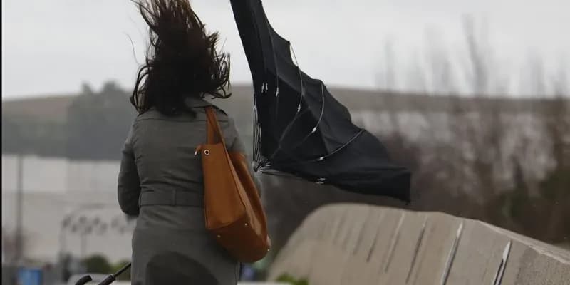 Mujer con paragüas al viento
