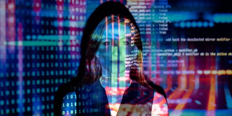 Mujer con proyecciones de código digital en su cara, representando tecnología y conceptos futuros