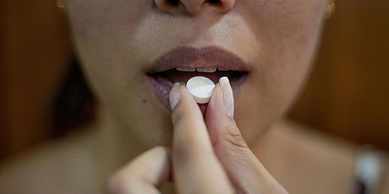 Mujer tomándose un medicamento