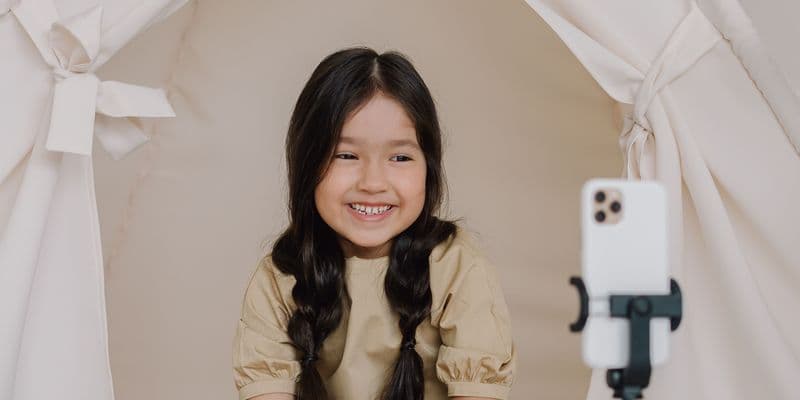 Niña sentada hablando a un teléfono