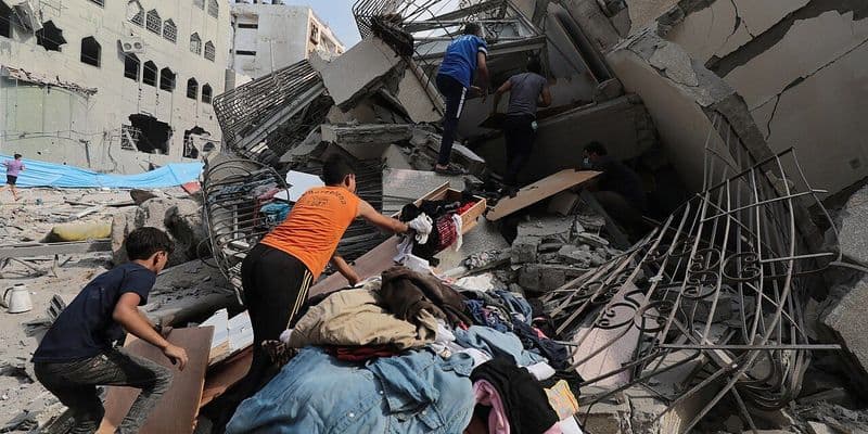 Palestinos inspeccionando las ruinas de Aklouk Tower destuida por misiles Israelies en Gaza