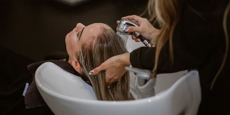 Peluquera lavando la cabeza de una clienta