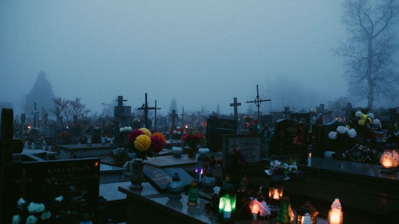 Cementerio de noche con lápidas iluminadas tenuemente