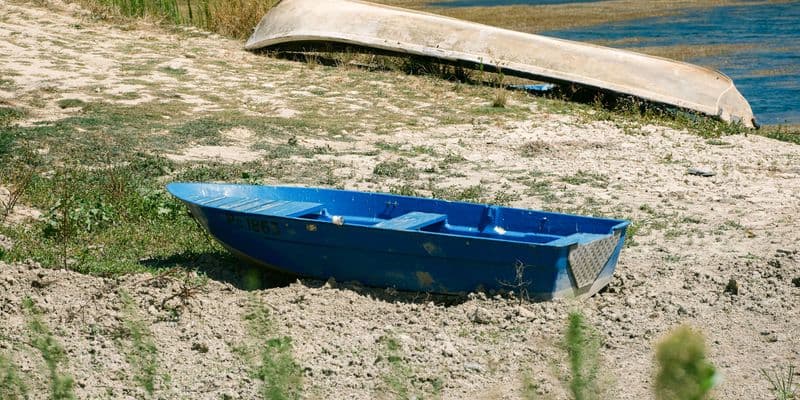Barca en un río seco durante una sequía de verano