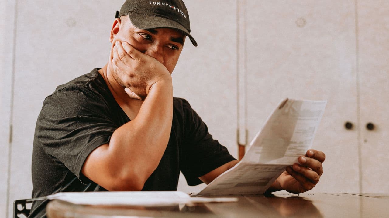 Persona preocupada leyendo una carta