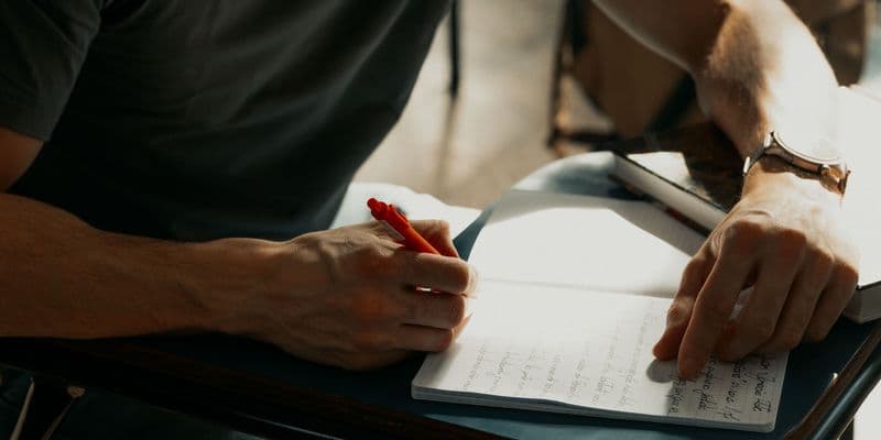 Estudiantes toman apuntes a mano durante una clase universitaria