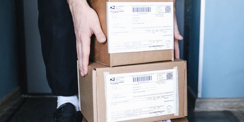 Persona recogiendo paquetes del suelo