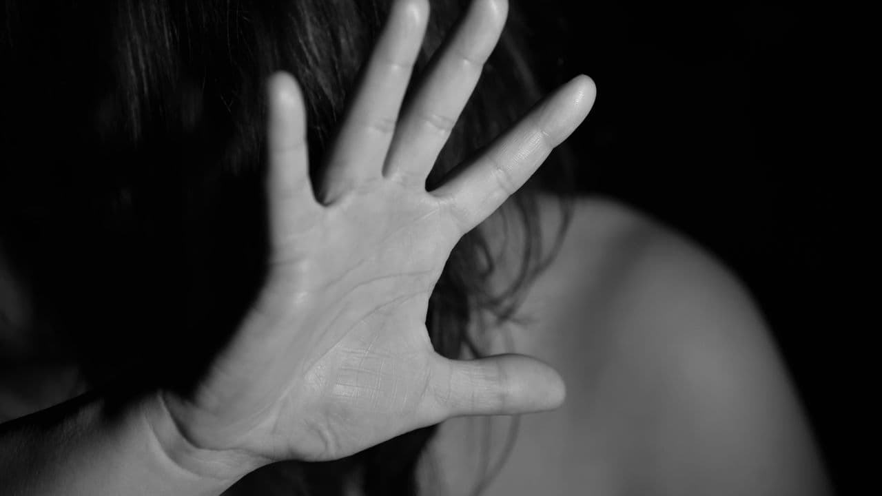 Mujer asustada protegiéndose con la mano