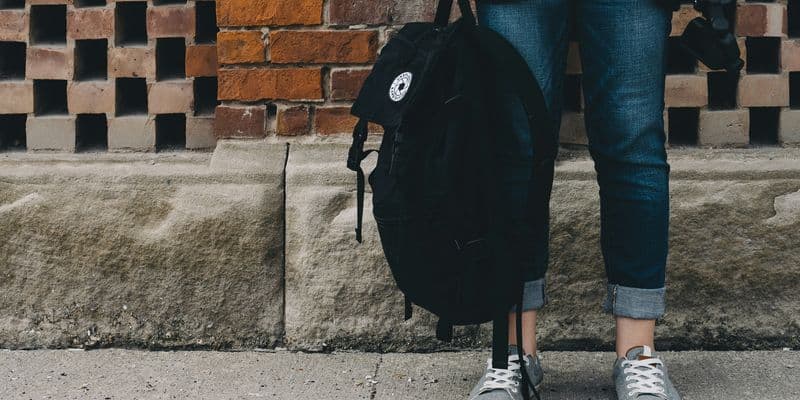Adolescente con una mochila en mano