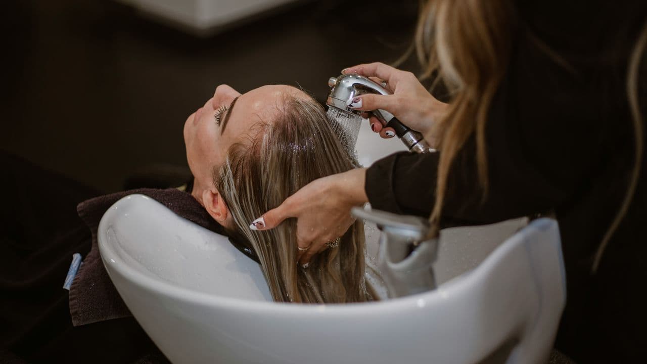 Peluquera lavando la cabeza de una clienta